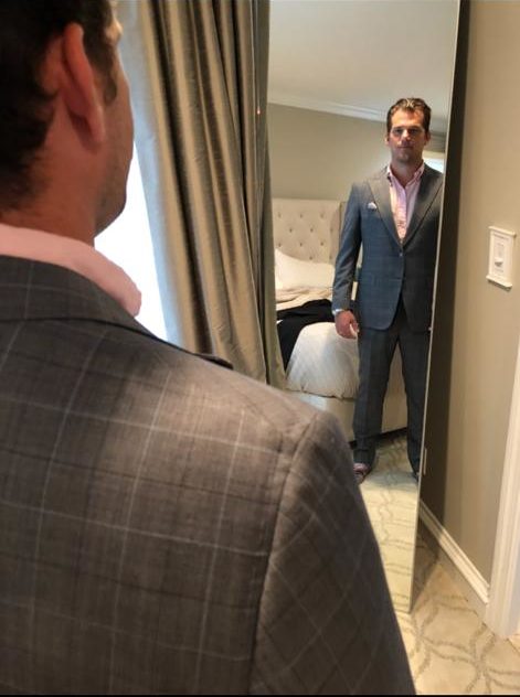 Man standing in front of mirror looking at custom suit